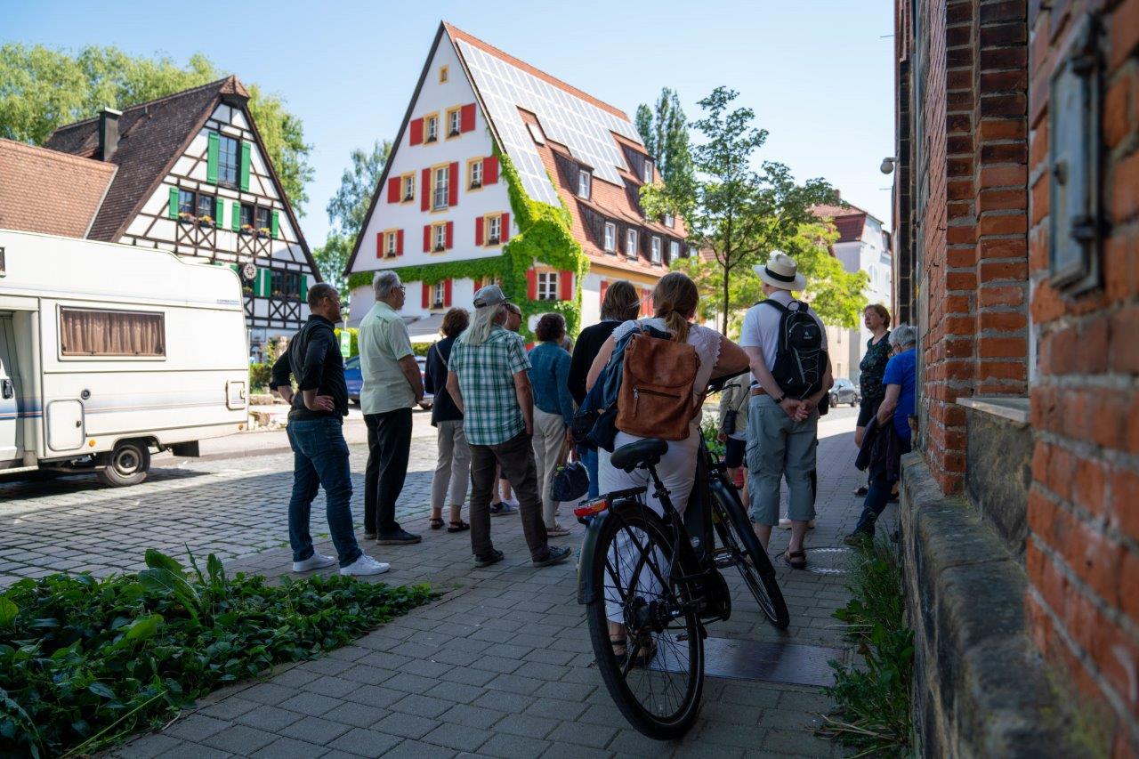 Gruppe bei einer Stadtführung vor dem Hotel Lohmühle.
