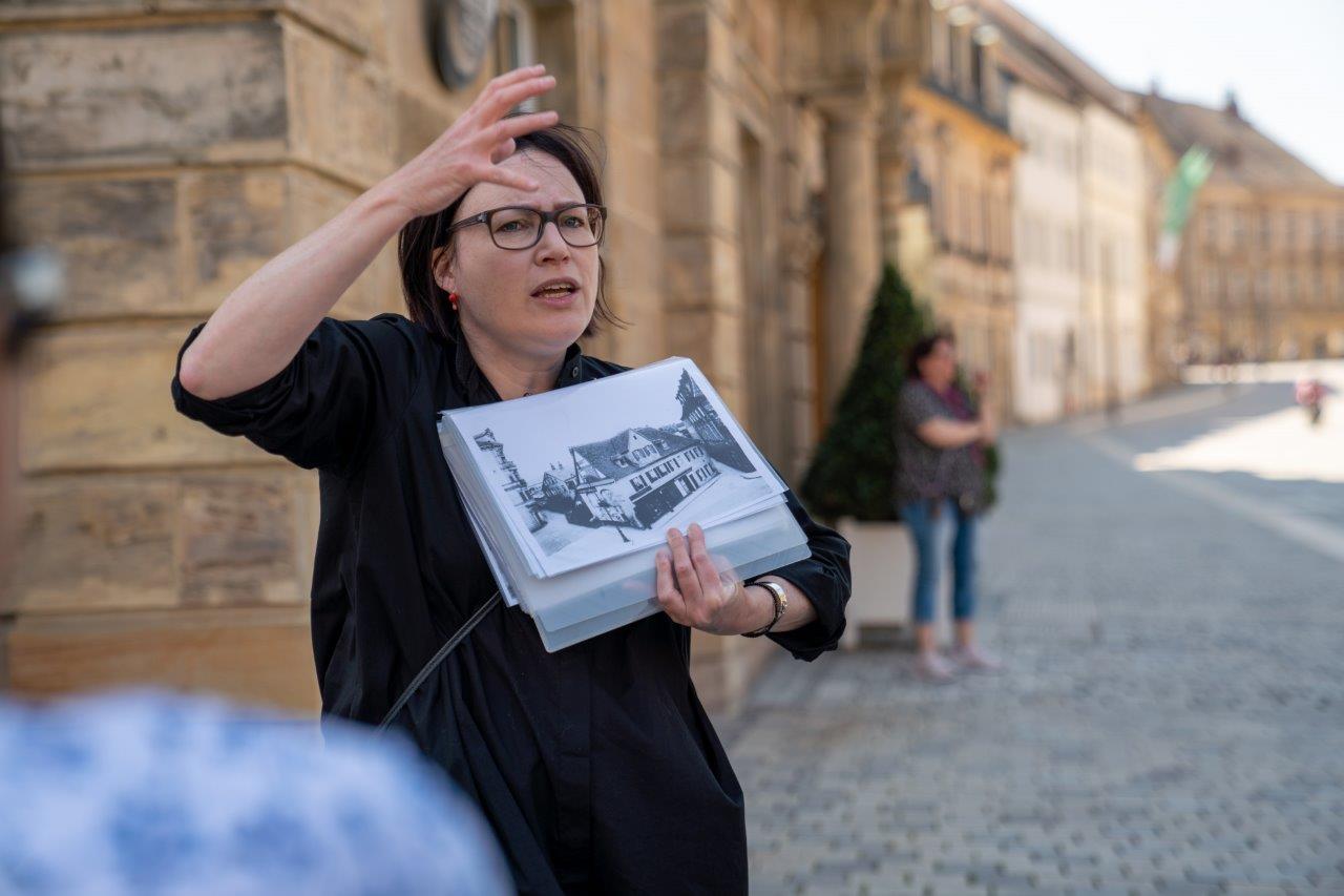 Eine Frau erklärt die Historie von Mühlen in der Stadt.