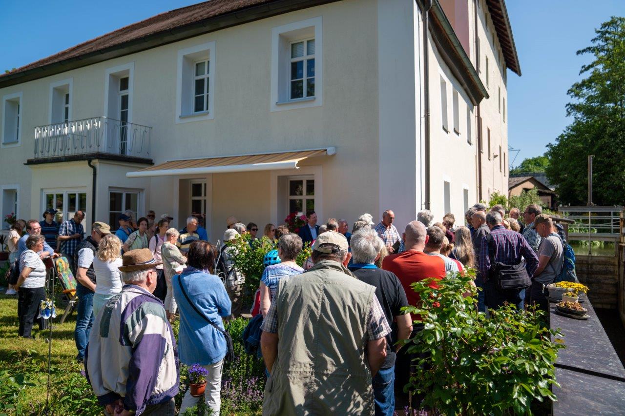 Gruppe von Menschen im Garten der Hölzleinsmühle.